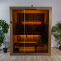 Front view of the Dundalk Leisurecraft Element Loft 3 Person Traditional Indoor Sauna with glass front and warm lighting