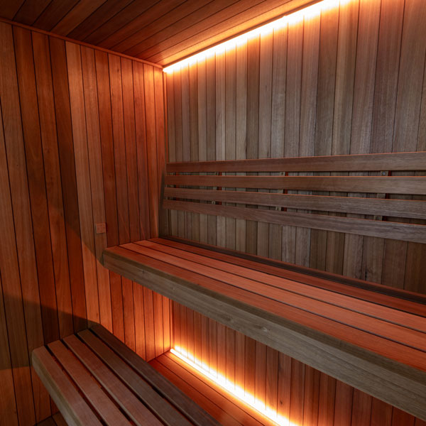 Corner benches and LED lighting inside the Dundalk Leisurecraft Element Studio 4 Person Traditional Indoor Sauna