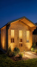Dundalk CT Palmer 4-Person Outdoor Cabin Sauna lit up at dusk in a backyard