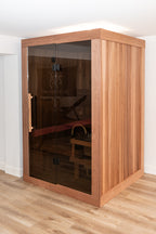 Angled view of the Dundalk Leisurecraft Element Nook 1-2 Person Traditional Indoor Sauna with glass door