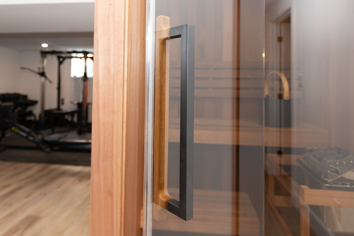 Glass door of the Dundalk Leisurecraft Element Nook 1-2 Person Traditional Indoor Sauna in a fitness room