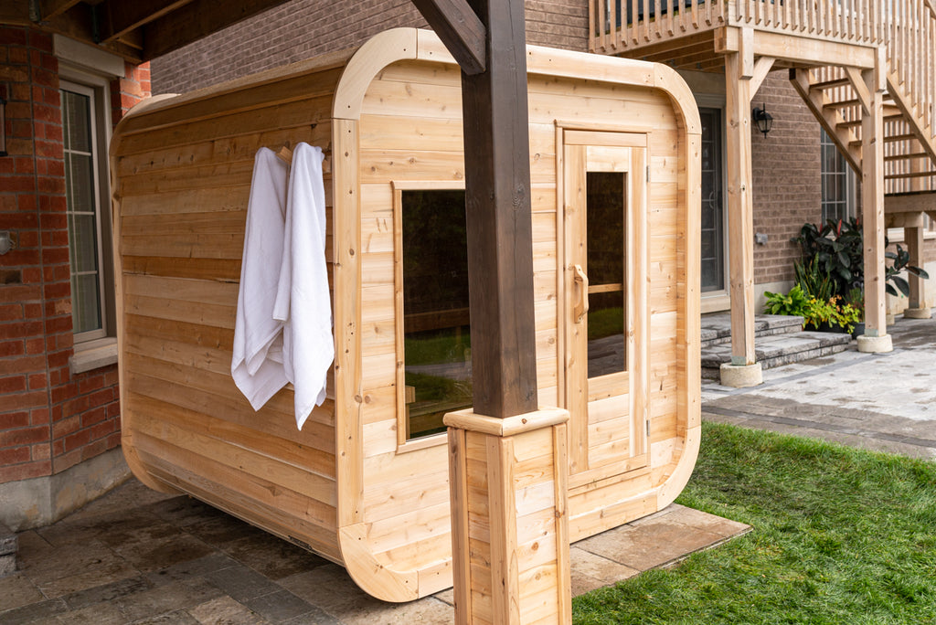 Side view of the Dundalk CT Luna 4-Person Outdoor Sauna with towels at the door