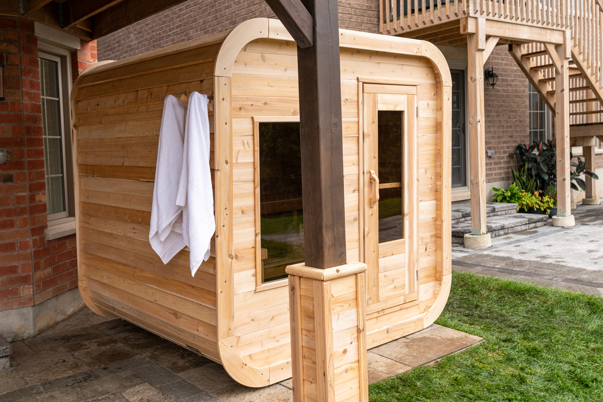 Side view of the Dundalk CT Luna 4-Person Outdoor Sauna with towels at the door
