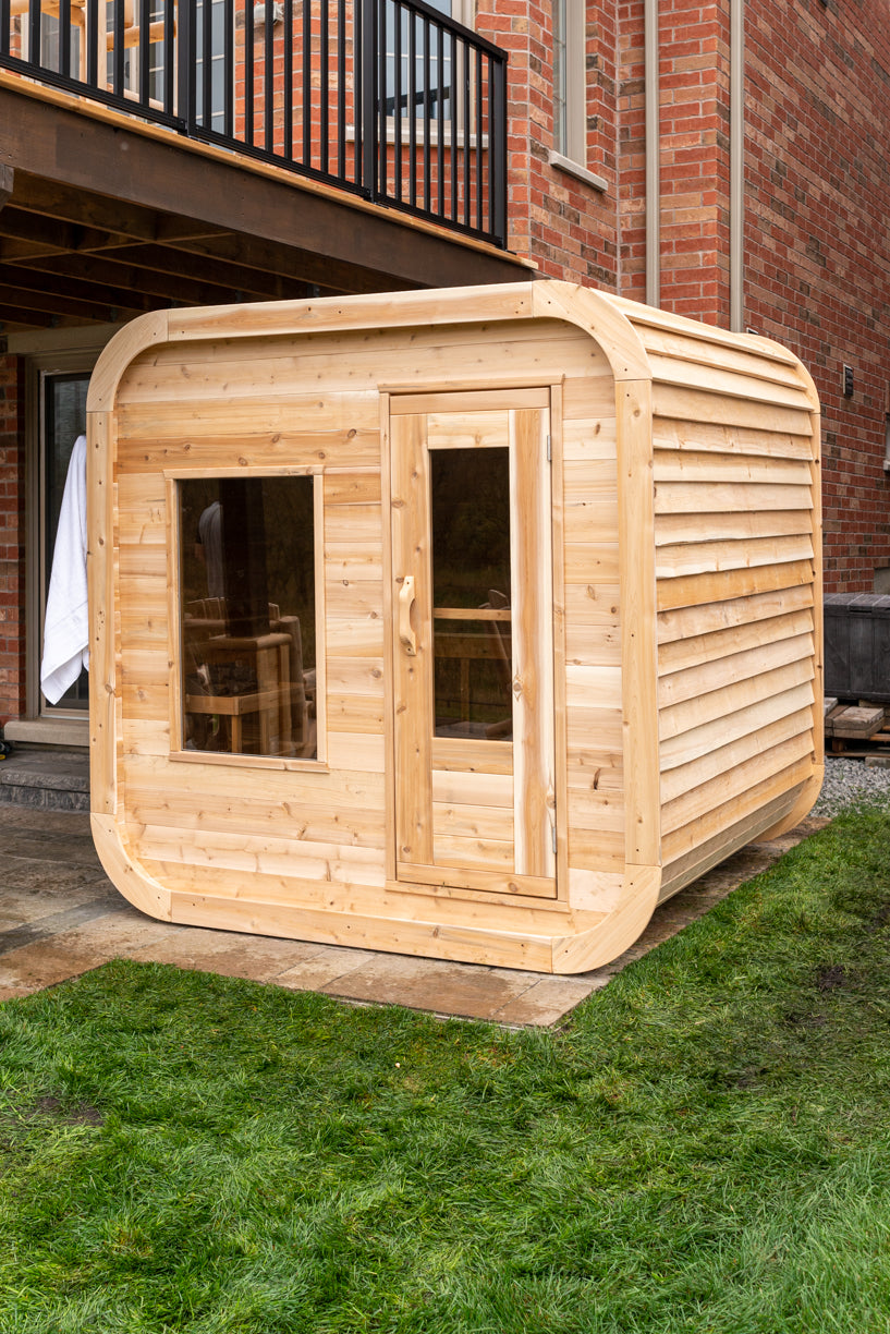 Front view of the Dundalk CT Luna 4-Person Outdoor Sauna with windows on a lawn