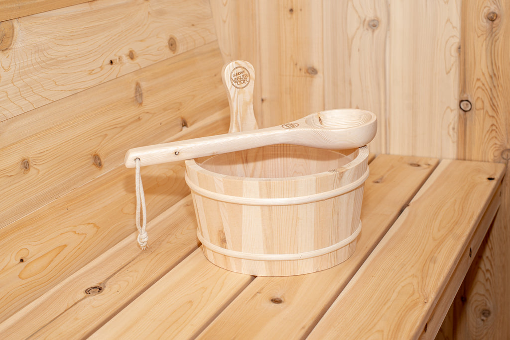 Wooden bucket and ladle on the bench inside the Dundalk CT Harmony 4-Person Outdoor Barrel Sauna