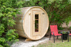 Dundalk CT Harmony 4-Person Outdoor Barrel Sauna beside red patio chairs