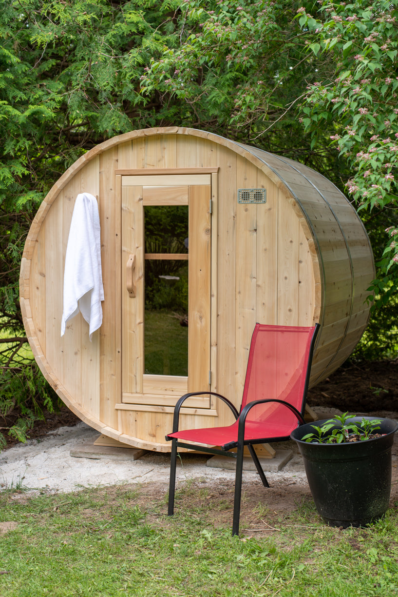 Front view of the Dundalk CT Harmony 4-Person Outdoor Barrel Sauna with a patio chair