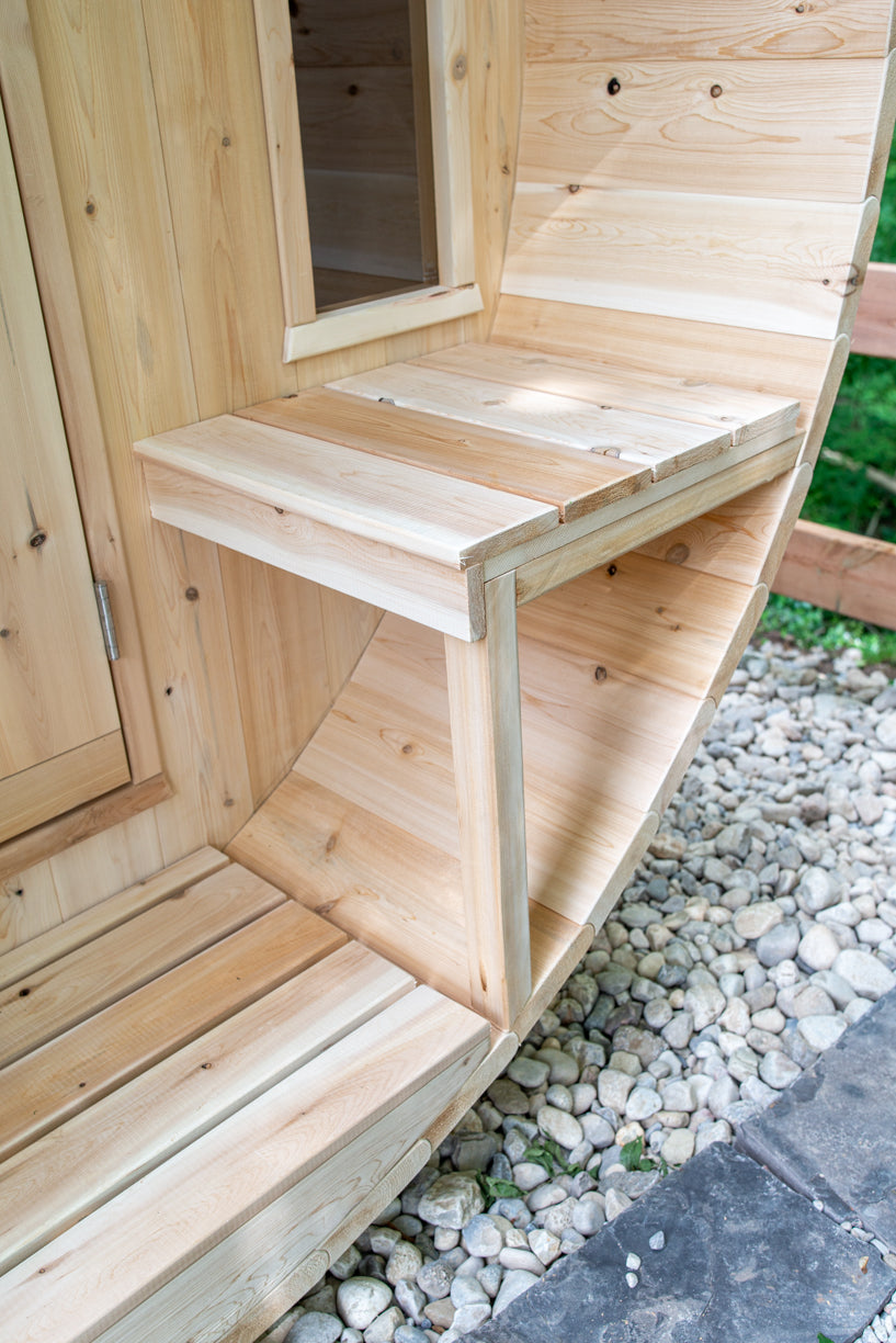 Porch bench beside the door of the Dundalk CT Tranquility 6-Person Outdoor Barrel Sauna
