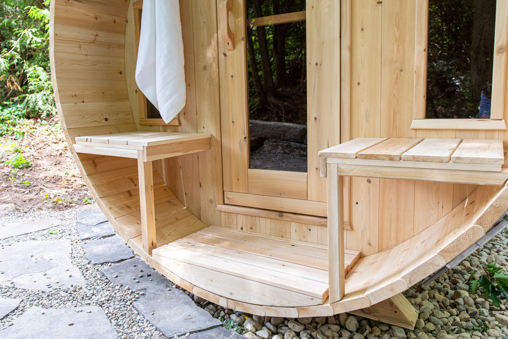 Front view of the Dundalk CT Tranquility 6-Person Outdoor Barrel Sauna with porch bench