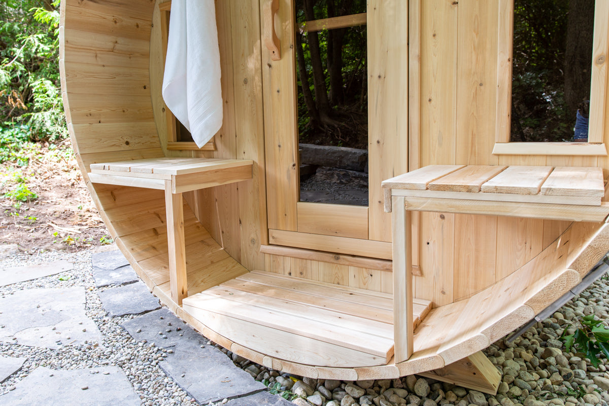 Front view of the Dundalk CT Tranquility 6-Person Outdoor Barrel Sauna with porch bench