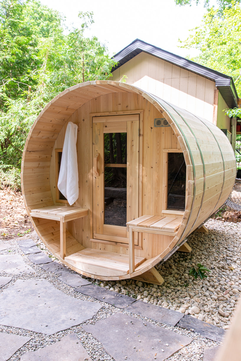 Angled view of the Dundalk CT Tranquility 6-Person Outdoor Barrel Sauna with porch bench