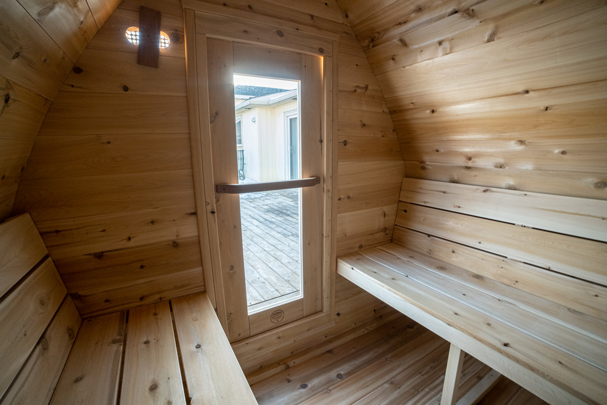 Interior of the Dundalk CT MiniPOD 4-Person Sauna with round window and wooden bench