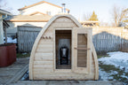 Front view of the Dundalk CT MiniPOD 4-Person Sauna with door and window in a backyard