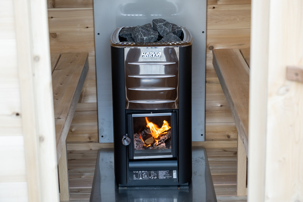 Wood stove with fire burning inside the Dundalk CT MiniPOD 4-Person Sauna