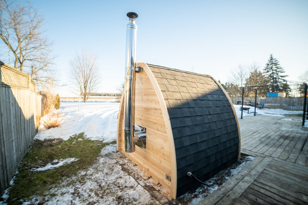 Dundalk CT MiniPOD 4-Person Sauna with chimney pipe in a winter yard