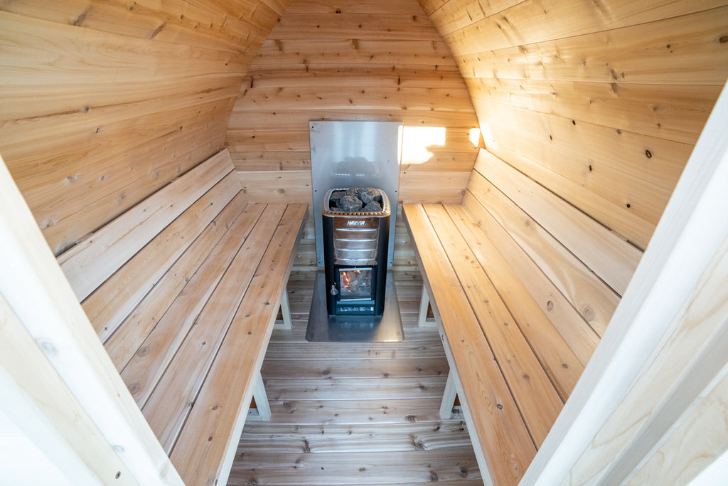 Interior of the Dundalk CT MiniPOD 4-Person Sauna with benches leading to the wood stove