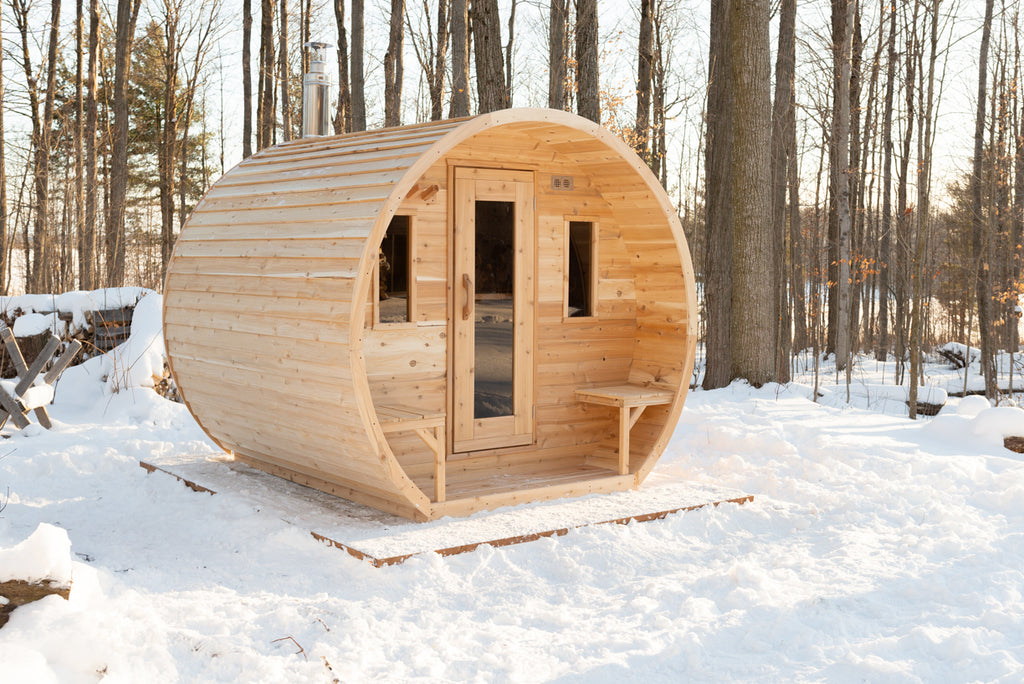 Dundalk CT Elation 4-Person Outdoor Barrel Sauna in a snowy forest