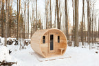 Dundalk CT Elation 4-Person Outdoor Barrel Sauna among trees in the snow