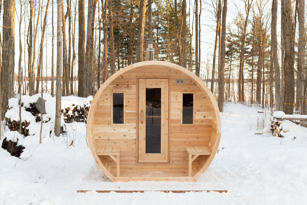 Dundalk CT Elation 4-Person Outdoor Barrel Sauna on a snowy forest floor