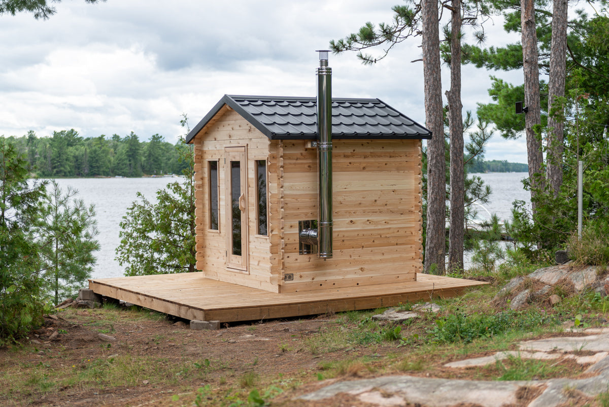 Front view of the Dundalk CT Georgian 6-Person Outdoor Cabin Sauna on a lakeside deck