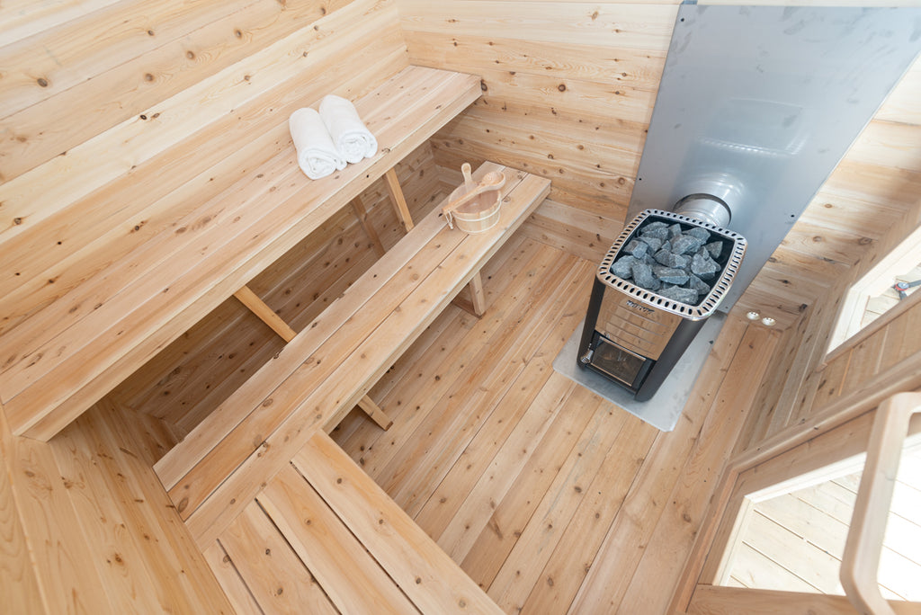 Corner benches and heater inside the Dundalk CT Georgian 6-Person Outdoor Cabin Sauna