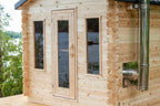 Side view of the Dundalk CT Georgian 6-Person Outdoor Cabin Sauna with windows and chimney pipe