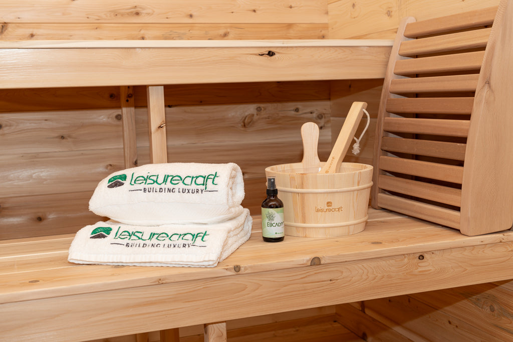 Towels, bucket and ladle on the bench inside the Dundalk CT Georgian 6-Person Cabin Sauna with Porch