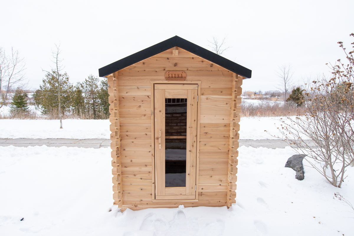 Front view of the Dundalk CT Granby 3-Person Outdoor Cabin Sauna in the snow