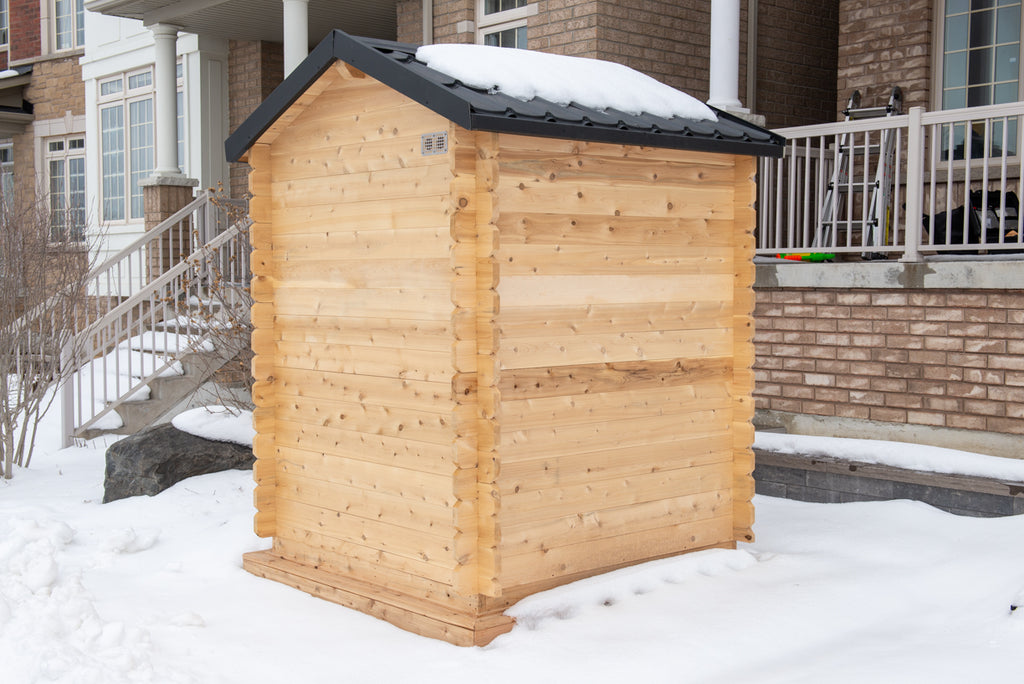 Rear view of the Dundalk CT Granby 3-Person Outdoor Cabin Sauna in the snow