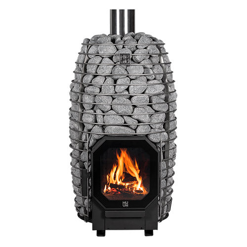 Huum Hive Flow 9.8kW wood-burning sauna stove with stacked sauna stones, chimney pipe and fire burning