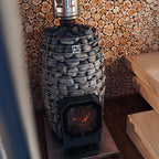 Huum Hive Flow Mini 8.5kW wood-burning sauna stove installed in a sauna with stones and wooden benches