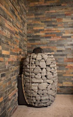 Huum Hive Wood LS 17kW wood-burning sauna stove with sauna stones installed in a sauna corner