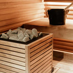Huum Core 10.5kW Sauna Heater with wooden slat cladding and sauna stones in a sauna