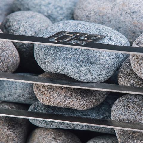 Close-up of the Huum logo and sauna stones on the Huum Cliff 9kW Sauna Heater