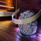 Huum Drop 4.5kW Sauna Heater in a sauna with curved wooden safety rail and floor plate
