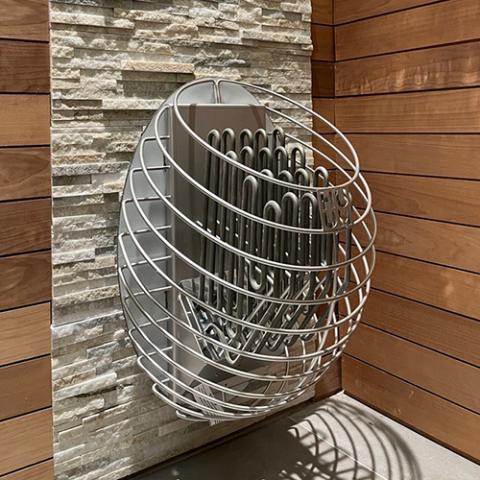 Huum Drop 7.5kW Sauna Heater mounted on a sauna wall of stone panels and wood