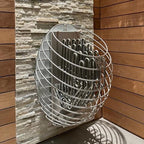 Huum Drop 6kW Sauna Heater mounted on a sauna wall of stone panels and wood