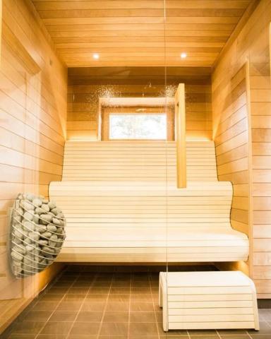 Huum Drop 6kW Sauna Heater mounted on the wall of a compact sauna