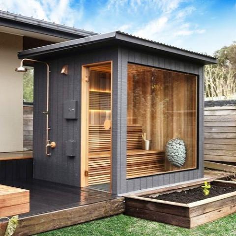 Outdoor sauna cabin with glass wall and Huum Drop 6kW Sauna Heater inside