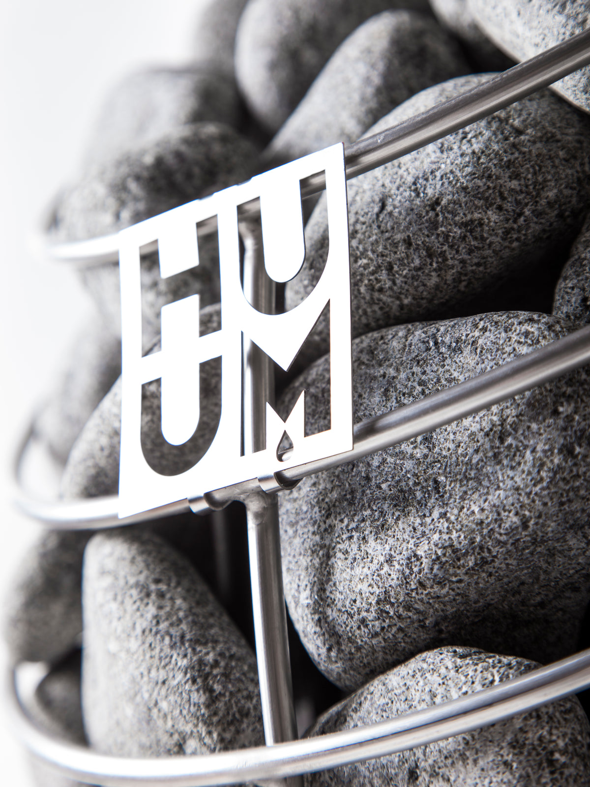 Close-up of the Huum logo on the stone cage of the Huum Drop 7.5kW Sauna Heater