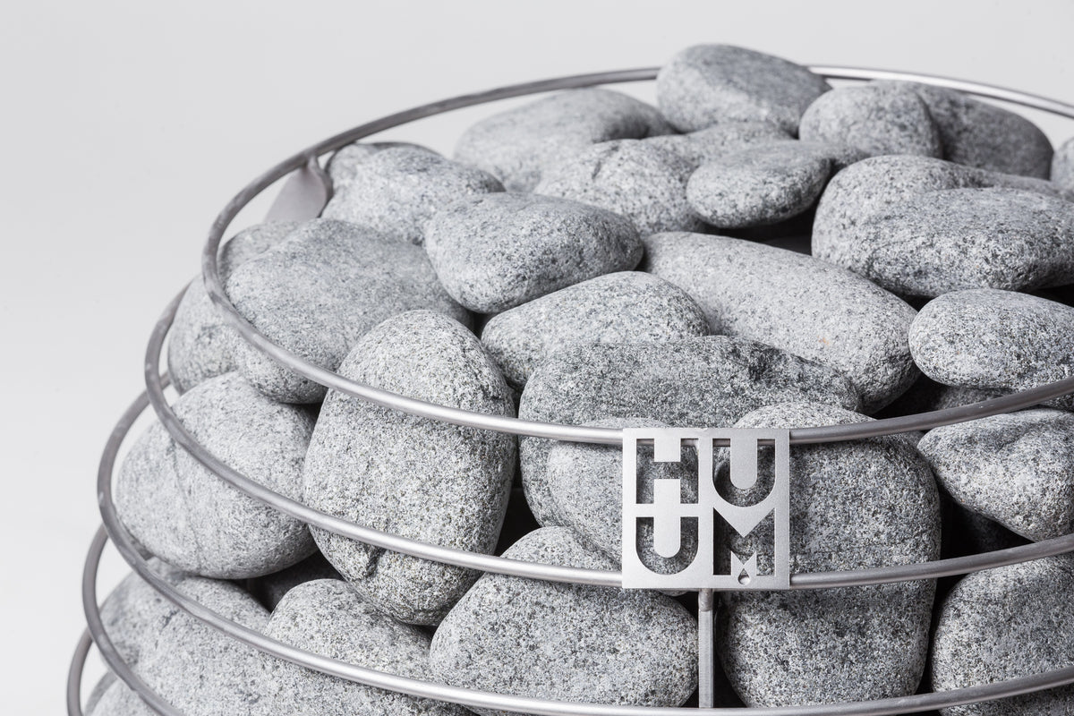 Close-up of the Huum logo on the stone cage of the Huum Hive 15kW Sauna Heater