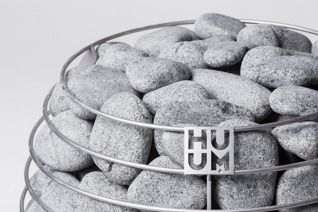 Close-up of the Huum logo on the stone cage of the Huum Hive 18kW Sauna Heater