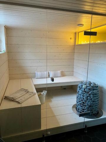 Huum Hive 15kW Sauna Heater in a sauna with white benches