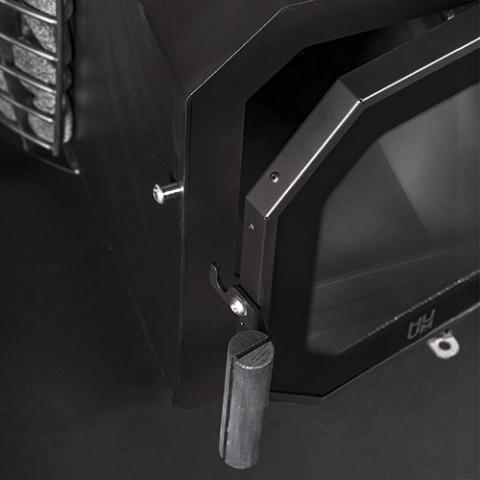 Close-up of the fire door handle on the Huum Hive Flow LS 9.8kW wood-burning sauna stove