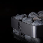 Close-up of the Huum logo and stone-filled top of the Huum Steel Mini 3.5kW Sauna Heater