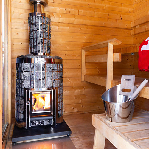 Harvia Cilindro 16 16kW Wood-Burning Sauna Stove in a sauna with bucket and ladle