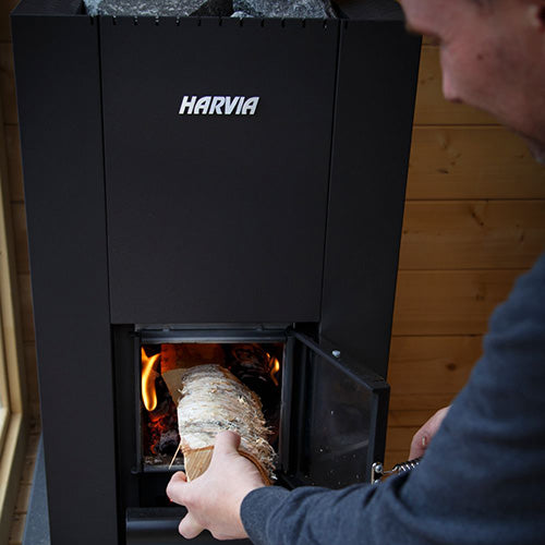 Loading firewood into the Harvia Linear 18 Compact 14.3kW Wood-Burning Sauna Stove