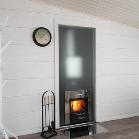 Harvia Pro 36 Duo 31kW Wood-Burning Sauna Stove and Fireplace installed through a wall, fireplace side facing the room
