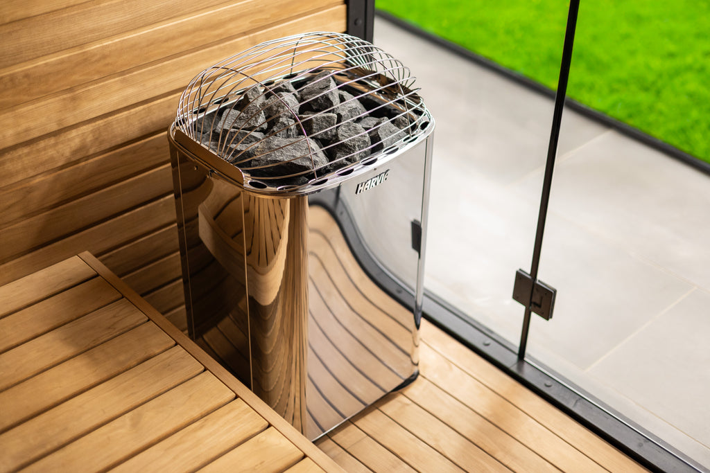 Harvia Club K12.5G 12.5kW electric sauna heater in an outdoor sauna with glass wall