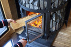 Loading firewood into the Harvia Legend 240 GreenFlame 15.9kW Wood-Burning Sauna Stove